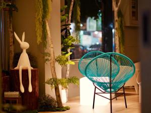 dwa krzesła w pokoju z roślinami i oknem w obiekcie Finders Hotel Hualien Station w mieście Hualian