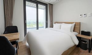 a bedroom with a large white bed and a window at Orange County Byeongjeom station in Hwaseong +37 photos