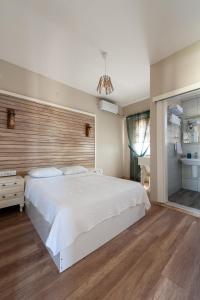 ボズジャ島にあるKarina Vineyard Houseのベッドルーム(白い大型ベッド1台、木製ヘッドボード付)