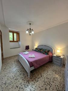 a bedroom with a large bed with a purple blanket at Casa Sonia in Osilo