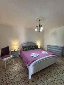 a bedroom with a bed and a chair and a chandelier at Casa Sonia in Osilo