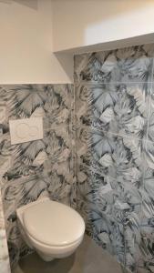 La salle de bains est pourvue de toilettes et de papier peint à fleurs. dans l'établissement House Mattia, à Bari