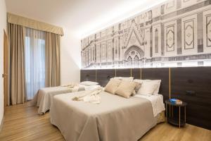 una camera d'albergo con due letti con lenzuola bianche di Hotel Mia Cara & Spa a Firenze