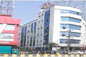 un edificio blanco alto con una grúa encima en OYO Hotel Hyderabad Heights, en Hyderabad