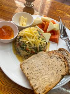 a white plate of food with cheese and bread and vegetables at Andrew Home in Kathmandu