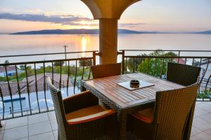 een tafel en stoelen op een balkon met uitzicht op het water bij Sea view in Sveti Juraj