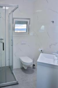 een badkamer met een toilet, een wastafel en een raam bij Sea view in Sveti Juraj
