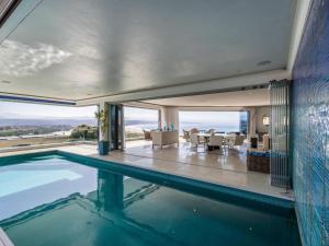 an indoor swimming pool in a house with a view at Keurbooms Lagoon Villa in Plettenberg Bay