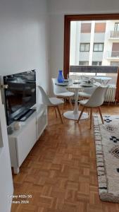 ein Wohnzimmer mit einem Tisch und Stühlen sowie eine Küche in der Unterkunft T2 rénové hyper centre Annecy in Annecy