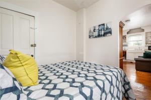 Dormitorio con cama con almohada amarilla en The Pull-String Penthouse at Timberline Flats, en Traverse City