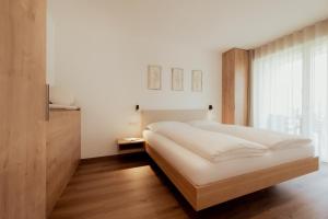 a bedroom with a large white bed and a window at Gutshof Ebner in San Paolo +64 photos