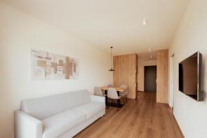 a living room with a white couch and a table at Gutshof Ebner in San Paolo