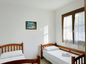 two beds in a room with two windows at Viola House in Villasimius