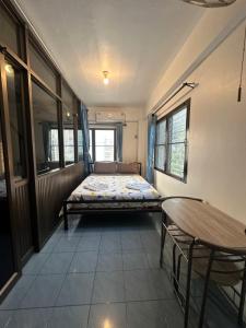 mały pokój z łóżkiem i stołem w obiekcie Mina house - มิณา เฮ้าส์ w mieście Ban Laem Thaen