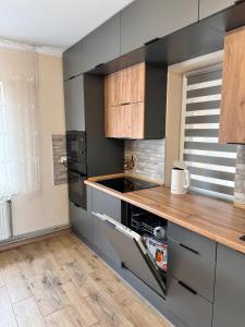 a kitchen with gray cabinets and a wooden counter top at N V New View in Yaremche