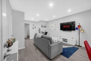Una sala de estar con un sofá y un televisor. en Modern & Spacious Guest Suite, en Calgary