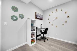 Habitación con escritorio y reloj en la pared en Modern & Spacious Guest Suite, en Calgary