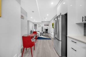 cocina y sala de estar con mesa y nevera en Modern & Spacious Guest Suite, en Calgary