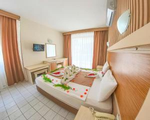 a bedroom with a large bed with vegetables on it at Mr Crane Hotel in Kemer