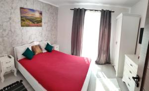 a bedroom with a bed with a red blanket at Apartament Gabriela in Baia Mare +17 photos