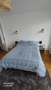 Schlafzimmer mit einem Bett mit blauer Decke in der Unterkunft T2 rénové hyper centre Annecy in Annecy