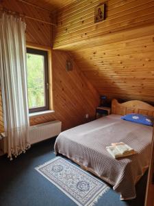 um quarto com uma cama num quarto de madeira em Voro Mold em Gura Humorului