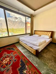 ein Schlafzimmer mit einem Bett und einem großen Fenster in der Unterkunft Skardu Luxus Hotel in Skardu