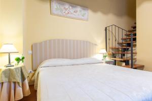 - une chambre avec un grand lit blanc et un escalier dans l'établissement Hotel Sant'Andrea, à Ravenne