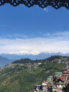 a view of snow capped mountains from a city at Dew Drops Guest House in Darjeeling