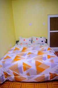- un lit avec une couette orange et blanche dans l'établissement Rafiki Apartment, à Zanzibar City
