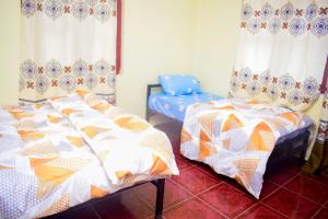 - une chambre avec deux lits et une chaise bleue dans l'établissement Rafiki Apartment, à Zanzibar City