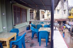 un patio avec des chaises et des tables bleues dans un bâtiment dans l'établissement Rafiki Apartment, à Zanzibar City