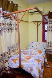 - une chambre avec un lit doté d'un cadre de lit en bois dans l'établissement Rafiki Apartment, à Zanzibar City