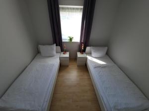 two beds in a room with a window at Ferienwohnung Nauen in Nauen