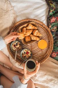 een persoon die een dienblad met ontbijtproducten en koffie vasthoudt bij Ker Amice , une parenthèse de calme près de Bordeaux , 3 chambres avec Spa Privatif in Saint-Loubès