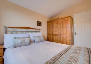 セント・メリリンにあるLittle Dolphins Atlantic Baysのベッドルーム1室(ベッド1台付)、木製キャビネットが備わります。