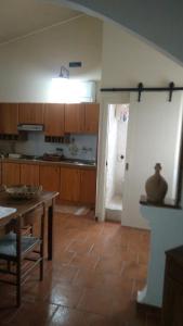una cocina con mesa y una puerta que da a una habitación en Villa Bruno, en Pisticci