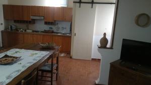 a kitchen with a table and a television and a kitchen with a table at Villa Bruno in Pisticci