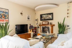 un soggiorno con 2 divani bianchi e una TV di Villa Le Rose - 5 minuti dal mare e Misano World Circuit a Misano Adriatico