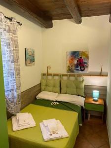Habitación pequeña con cama verde y mesa. en Rifugio Giudeo, en Balestrate