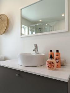 een badkamerbar met een wastafel en een spiegel bij Charming house in Ulsteinvik with free parking in Ulsteinvik