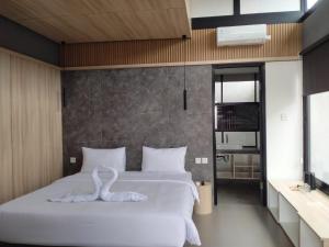 - une chambre avec un lit orné d'une sculpture de cygne dans l'établissement Lynn Resort Carita, à Sukarame