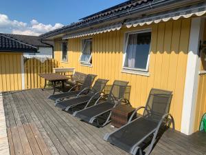 a group of chairs and a table on a deck at Apartment with access to pool and sauna in Porsgrunn
