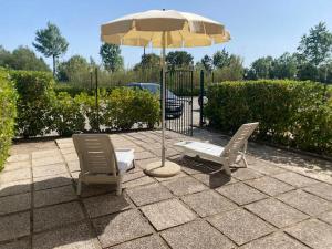 two chairs and an umbrella on a patio at Sofis Servizi Rio Grande (CAV) in Principina a Mare