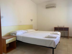 ein Schlafzimmer mit einem großen Bett und einem Schreibtisch in der Unterkunft Sofis Servizi Rio Grande (CAV) in Principina a Mare