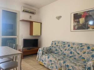 uma sala de estar com um sofá e uma televisão em Sofis Servizi Rio Grande (CAV) em Principina a Mare