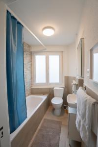 y baño con bañera, aseo y lavamanos. en Jungstay Apartments- near Basel, en Basilea