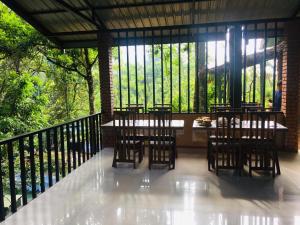 a table and chairs on a balcony with trees at Niwana Resorts kiriella in Kiriella