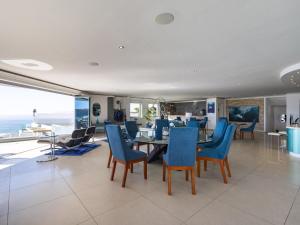 a dining room with blue chairs and a table at Keurbooms Lagoon Villa in Plettenberg Bay