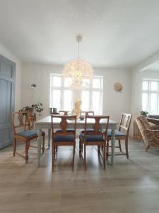 jadalnia ze stołem, krzesłami i żyrandolem w obiekcie Charming house in Ulsteinvik with free parking w mieście Ulsteinvik